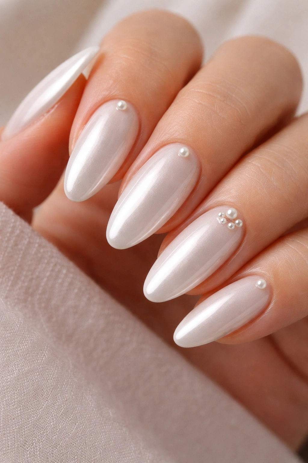 Close-up of White Chrome with Tiny Pearl Studs on almond nails with small pearl accents