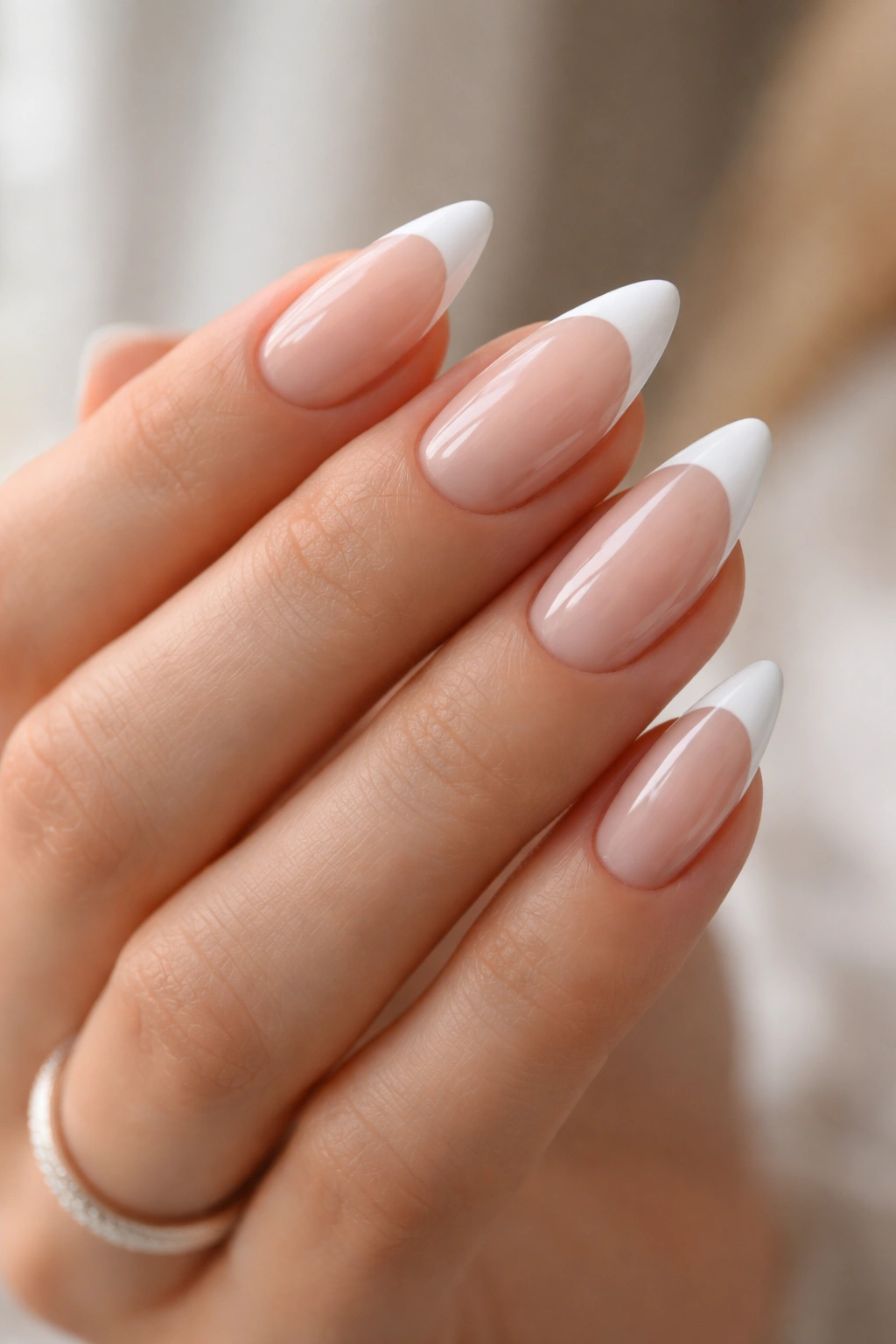 Almond nails with crisp white French tips on a sheer pink base