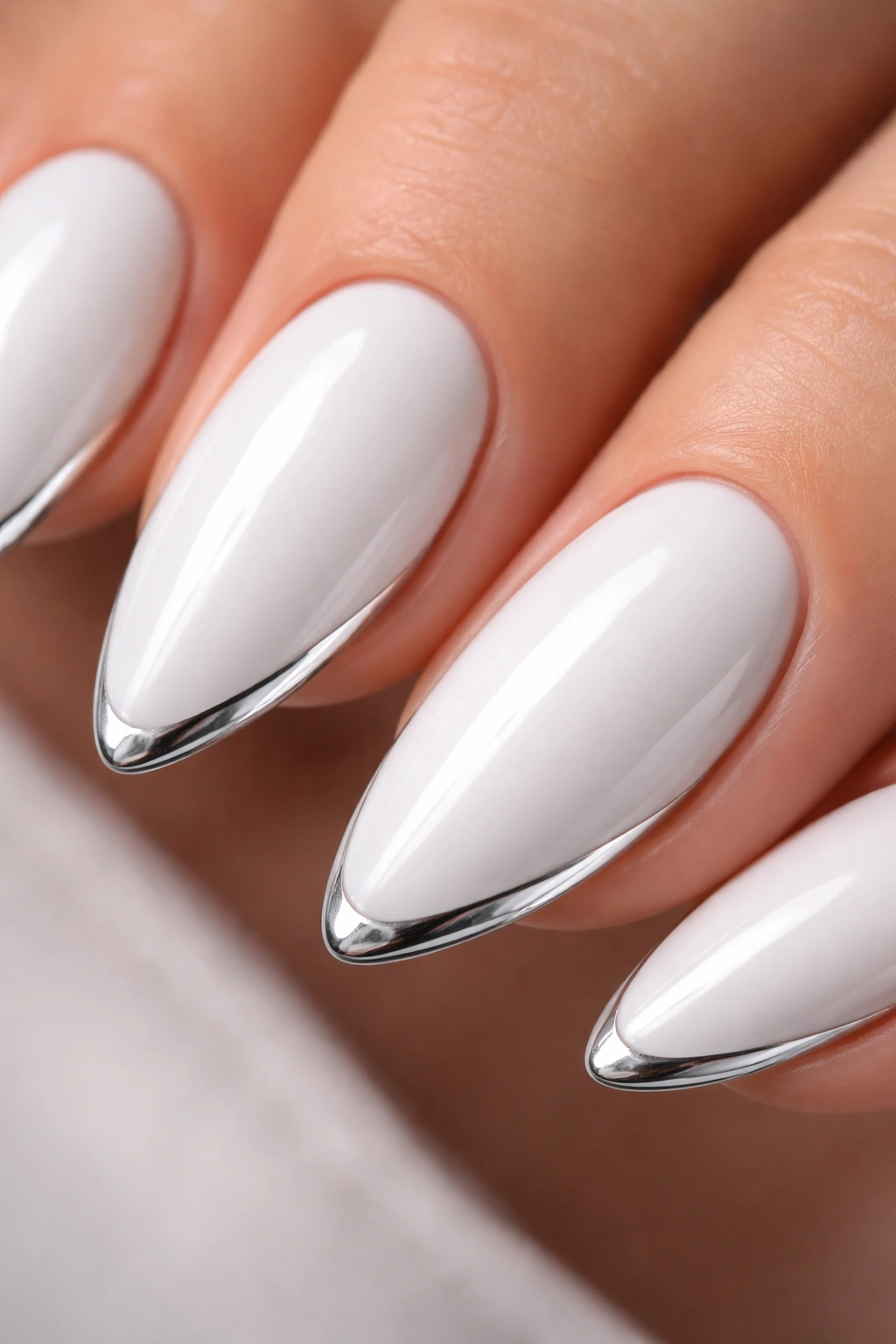 Close-up of white almond nails with a thin silver chrome edge along the tips