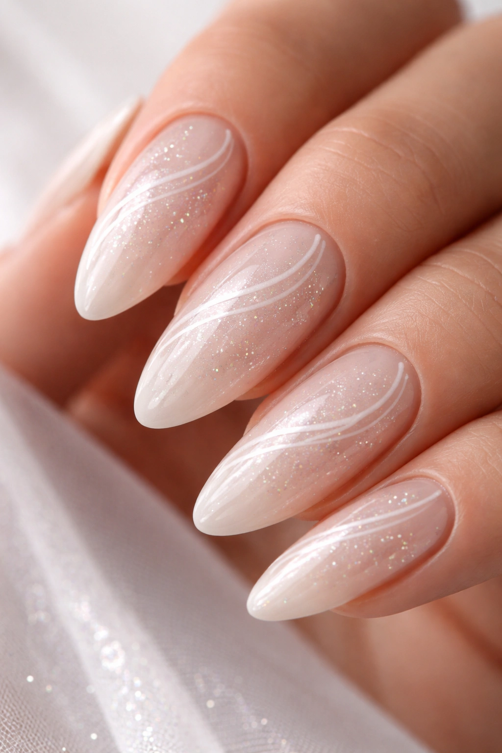 Close-up of white pearl glitter swirls on almond nails