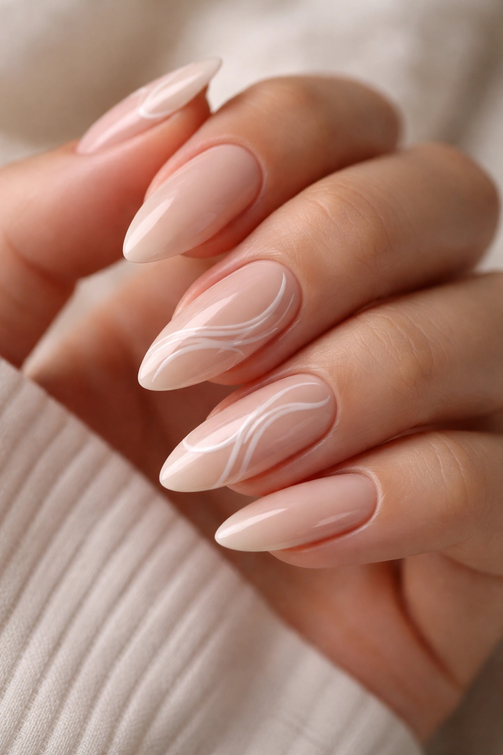 Almond nails with white swirl line art on a nude base