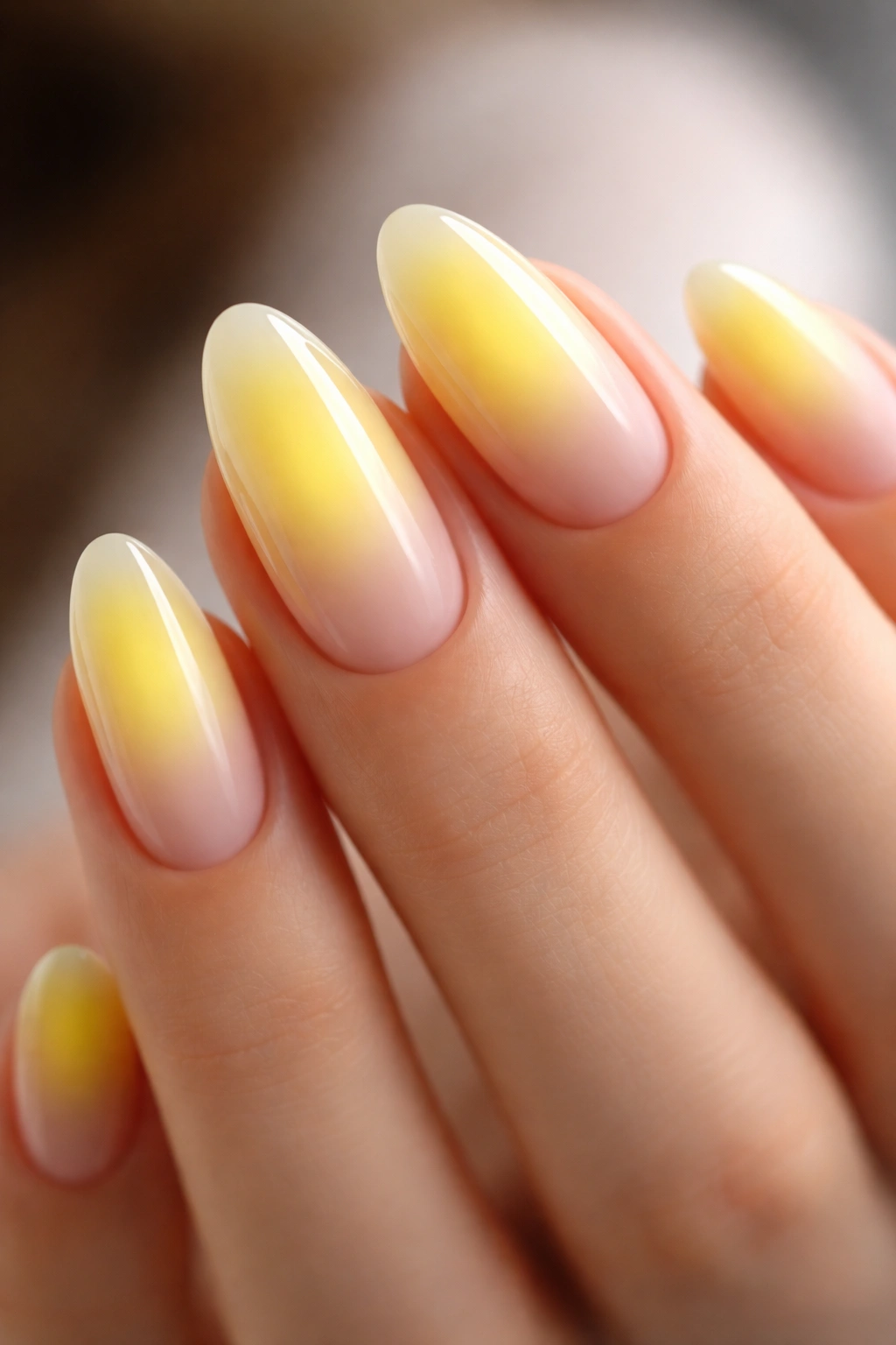 Almond nails with soft yellow aura gradient on nude base