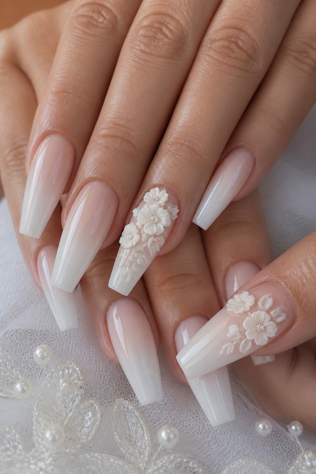Close-up of real hand showing 3D floral white ombre bridal nails on ring finger and thumb