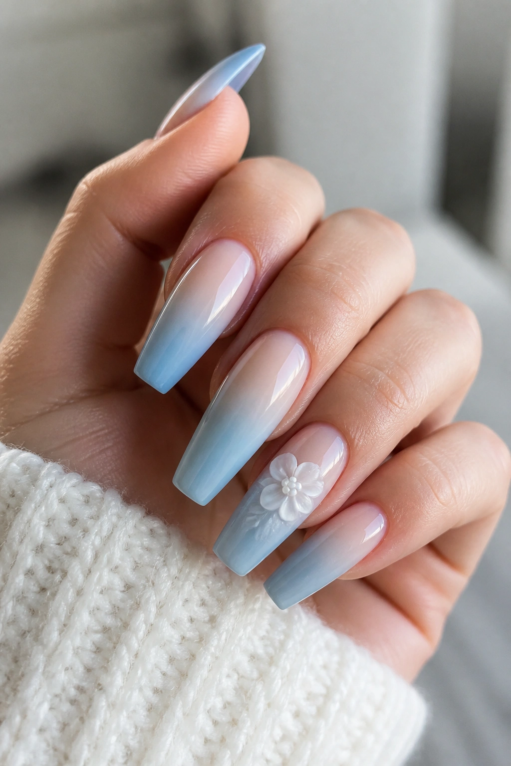 Close-up of 3D floral light blue ombre coffin nails on a real hand