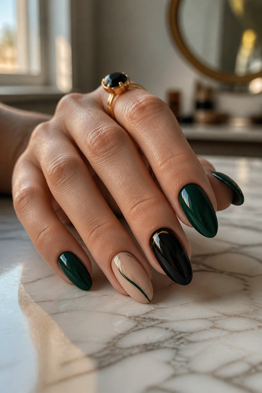 Close-up of almond nails in dark green with a nude accent and black ring finger on a real hand