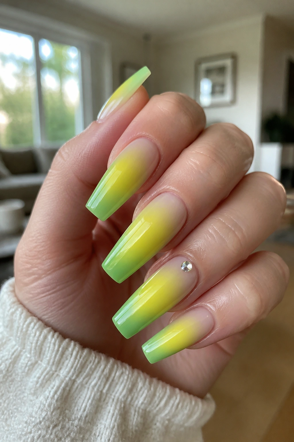 Close-up of green-yellow aura coffin nails on a real hand