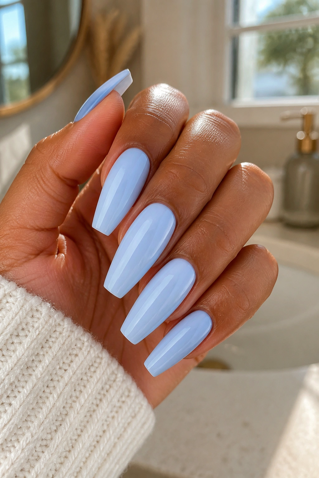Close-up of real hand with tapered coffin nails in soft baby blue