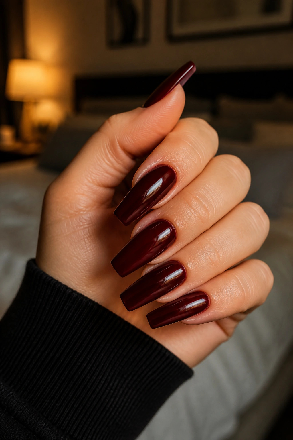Close-up of hand with black cherry red coffin nails glossy finish