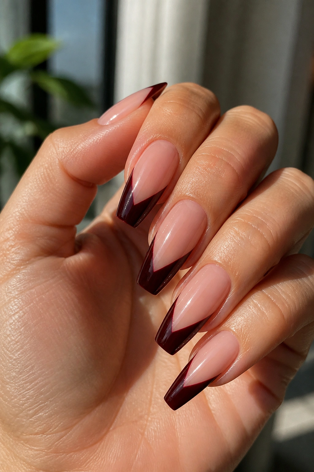 Close-up of coffin nails with black cherry V-cut tips and sharp smile lines