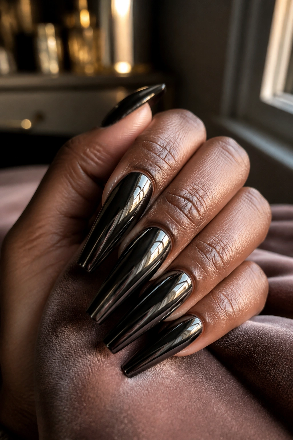 Close-up of black chrome coffin nails with liquid-metal finish on a real hand.