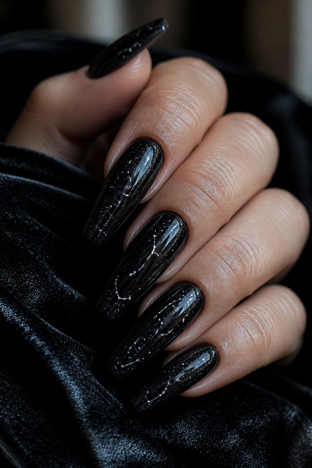 Close-up of black jelly coffin nails with tiny silver constellation dots on a real hand