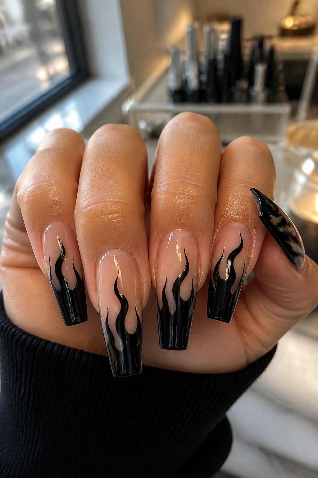 Close-up of black flame nail art on coffin nails on a real hand in a salon