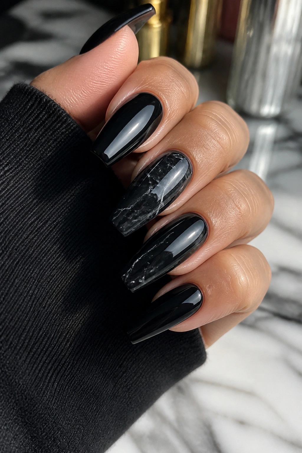 Close-up of black marble coffin nails with gray veining on a manicured hand
