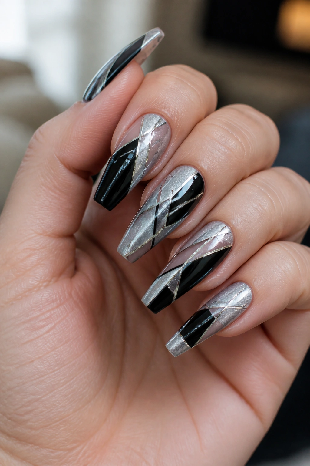 Close-up of hands showing black and silver geometric coffin nails on real hand