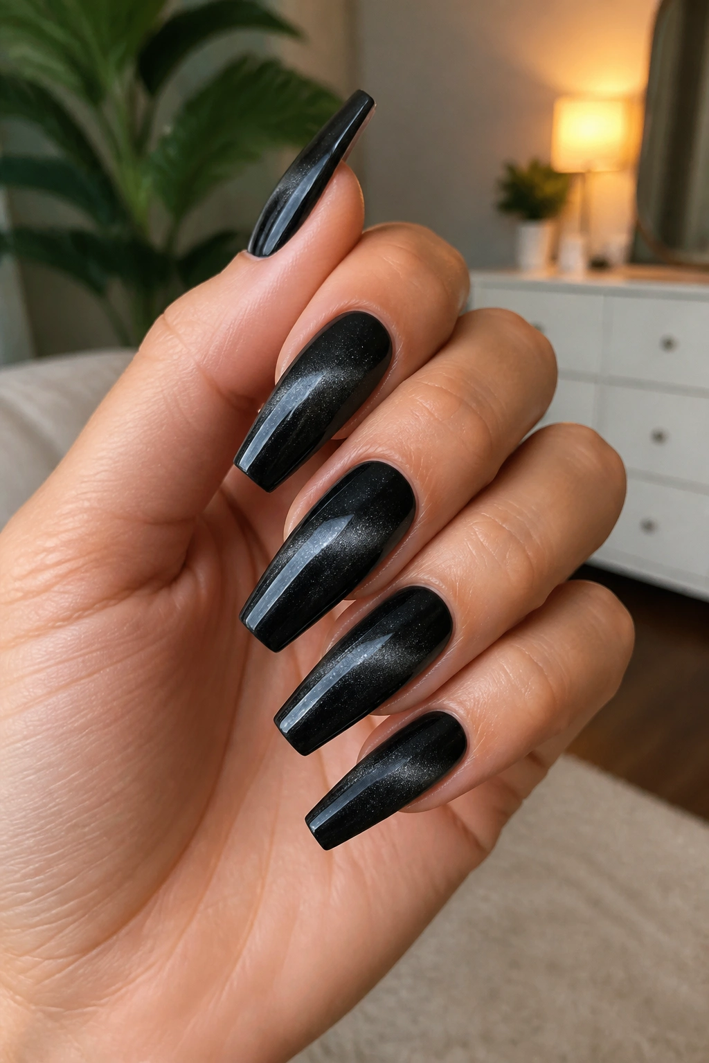 Close-up of black velvet cat-eye coffin nails with diagonal shimmer