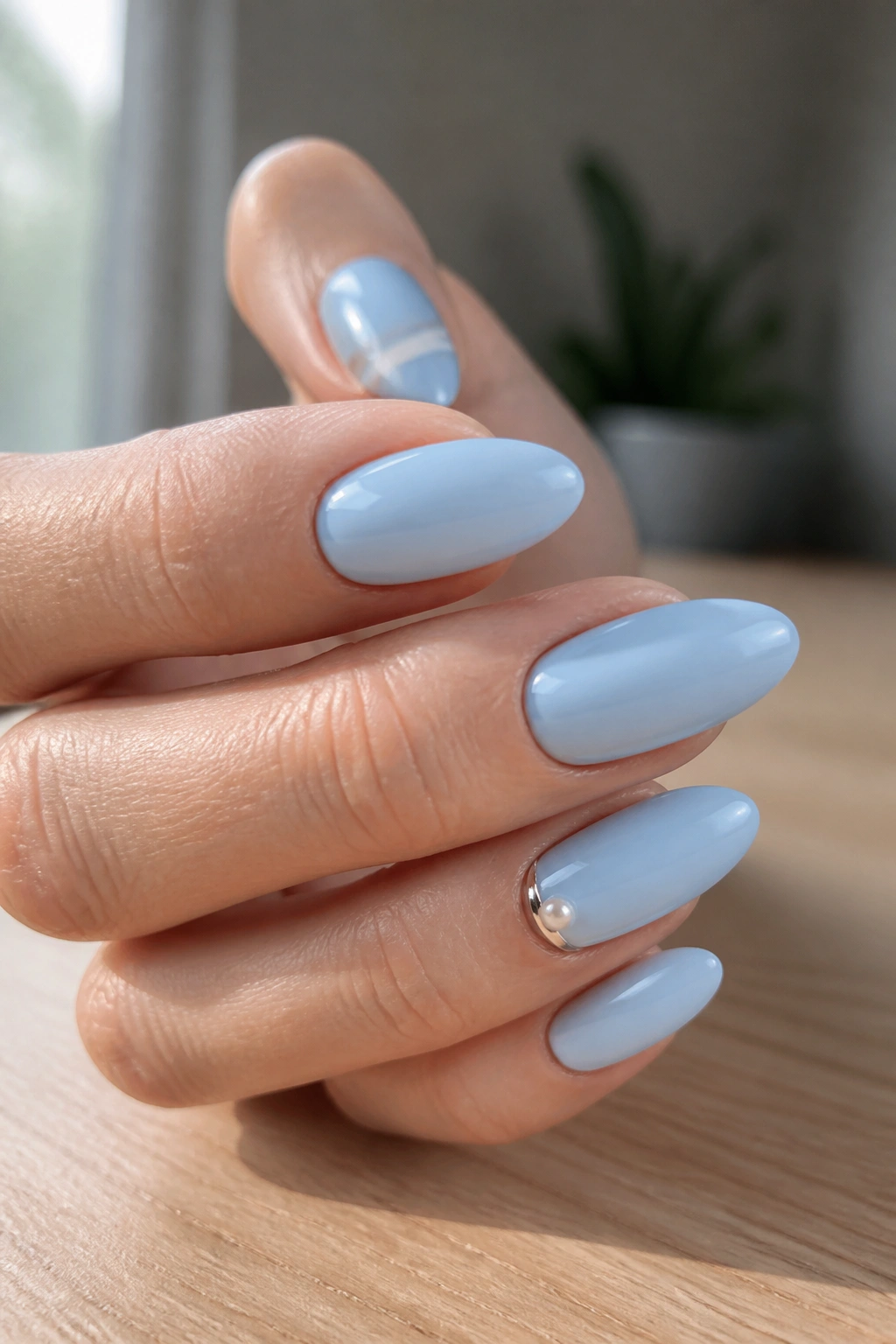 Close-up of blue almond nails with subtle accent on a hand