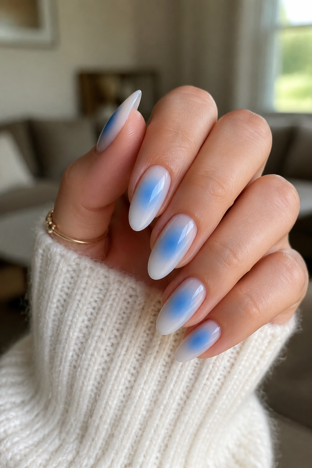 Almond nails with small blue glow aura on milky base
