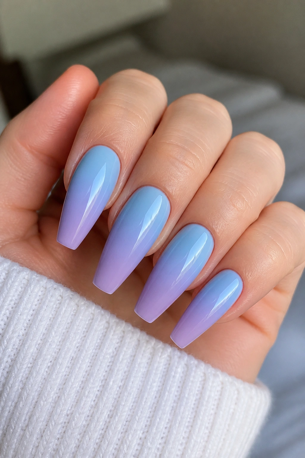 Close-up of blue-to-lilac ombre coffin nails on a real hand