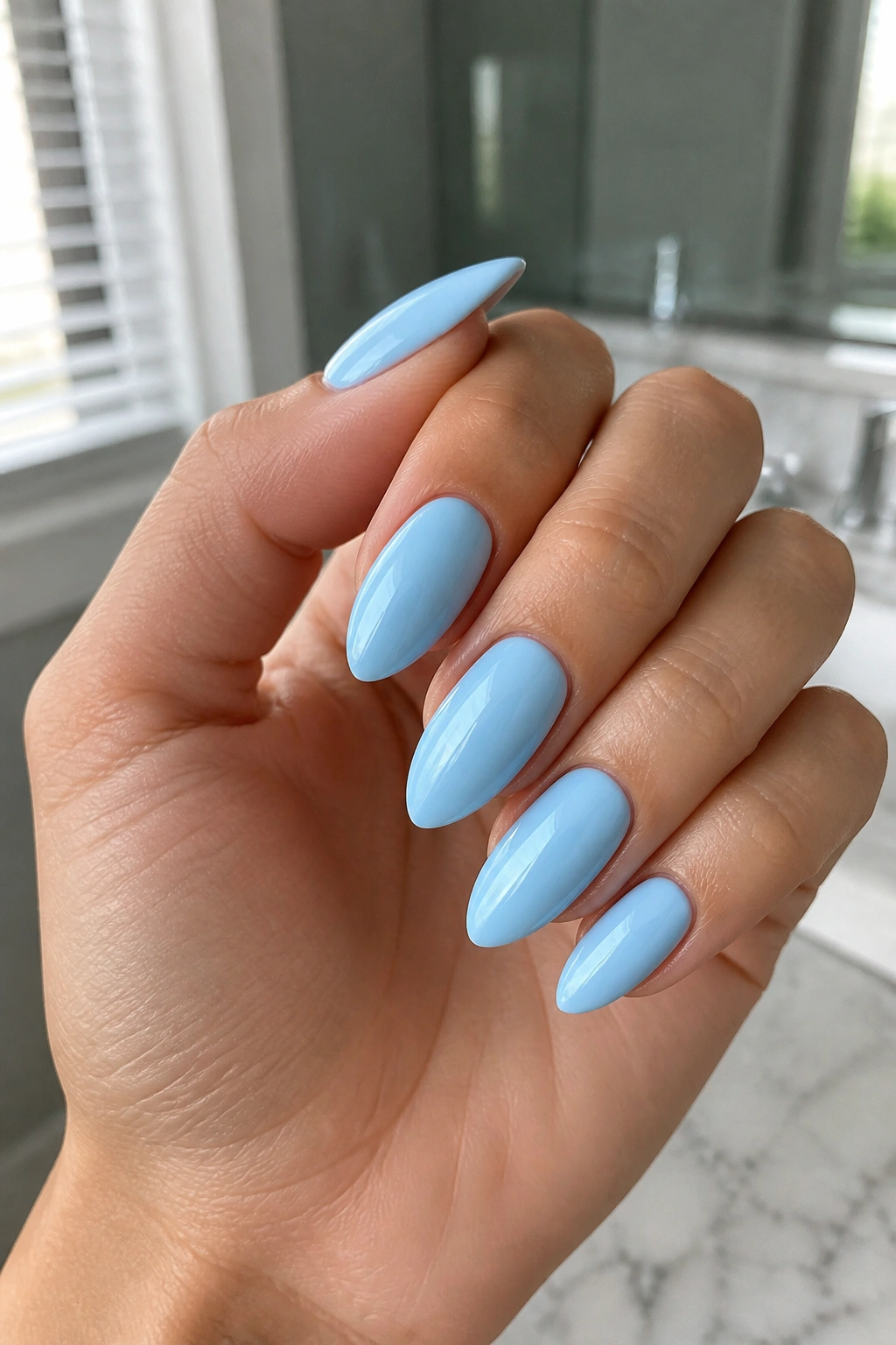 Close-up of baby blue almond nails with glossy finish