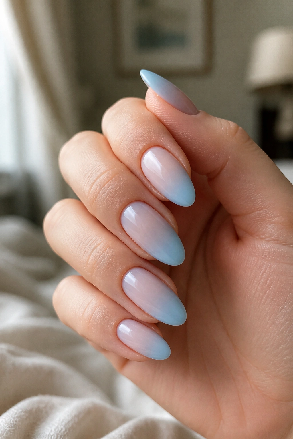 Almond nails with soft blue ombré against milky nude