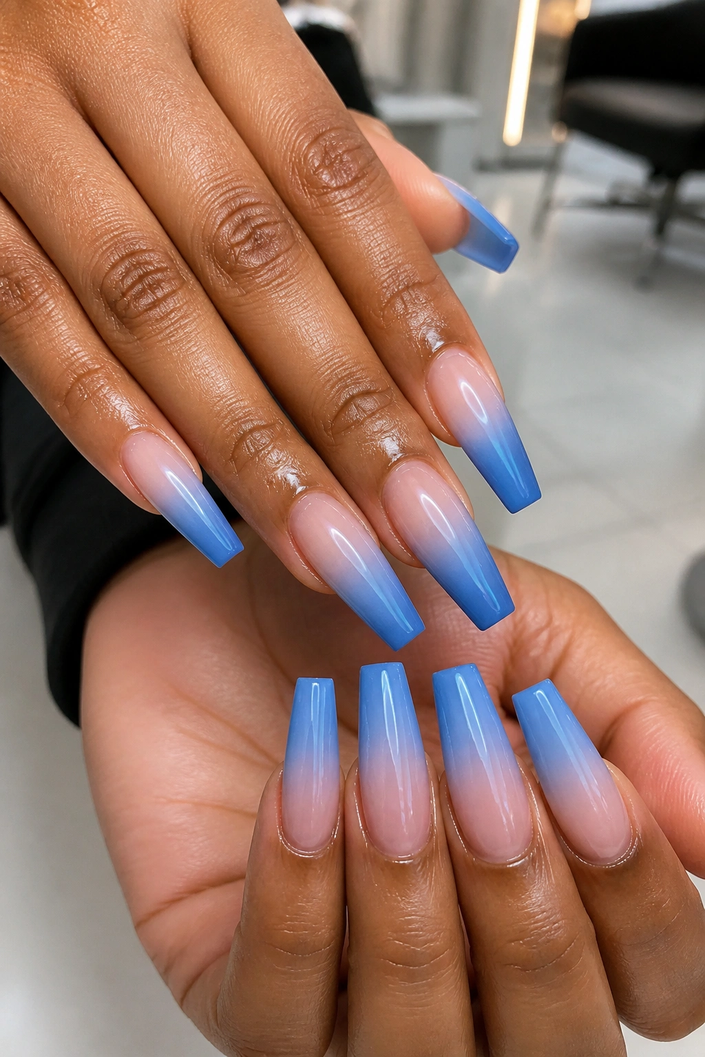 Close-up of smooth blue ombre coffin nails on a real hand in a salon