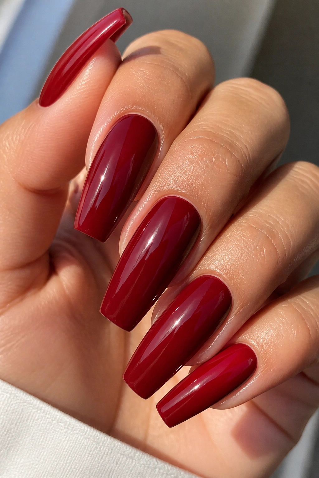Close-up of blue-red ruby cream coffin nails on a real hand