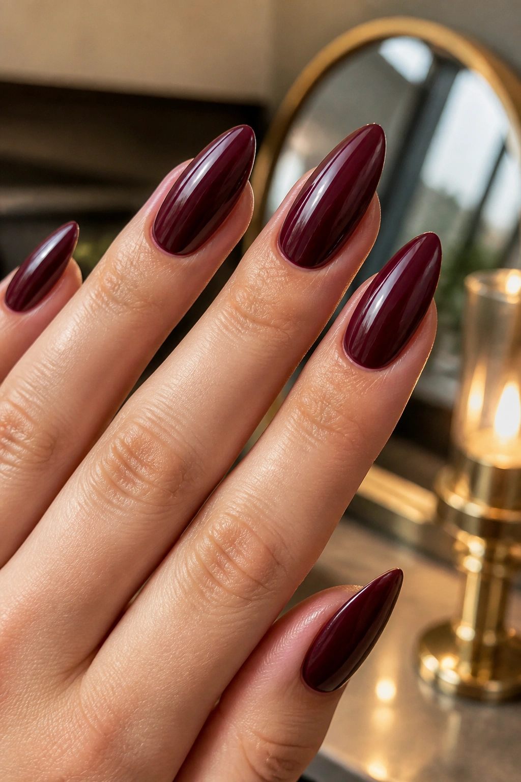 Close-up of deep burgundy almond nails on a real hand