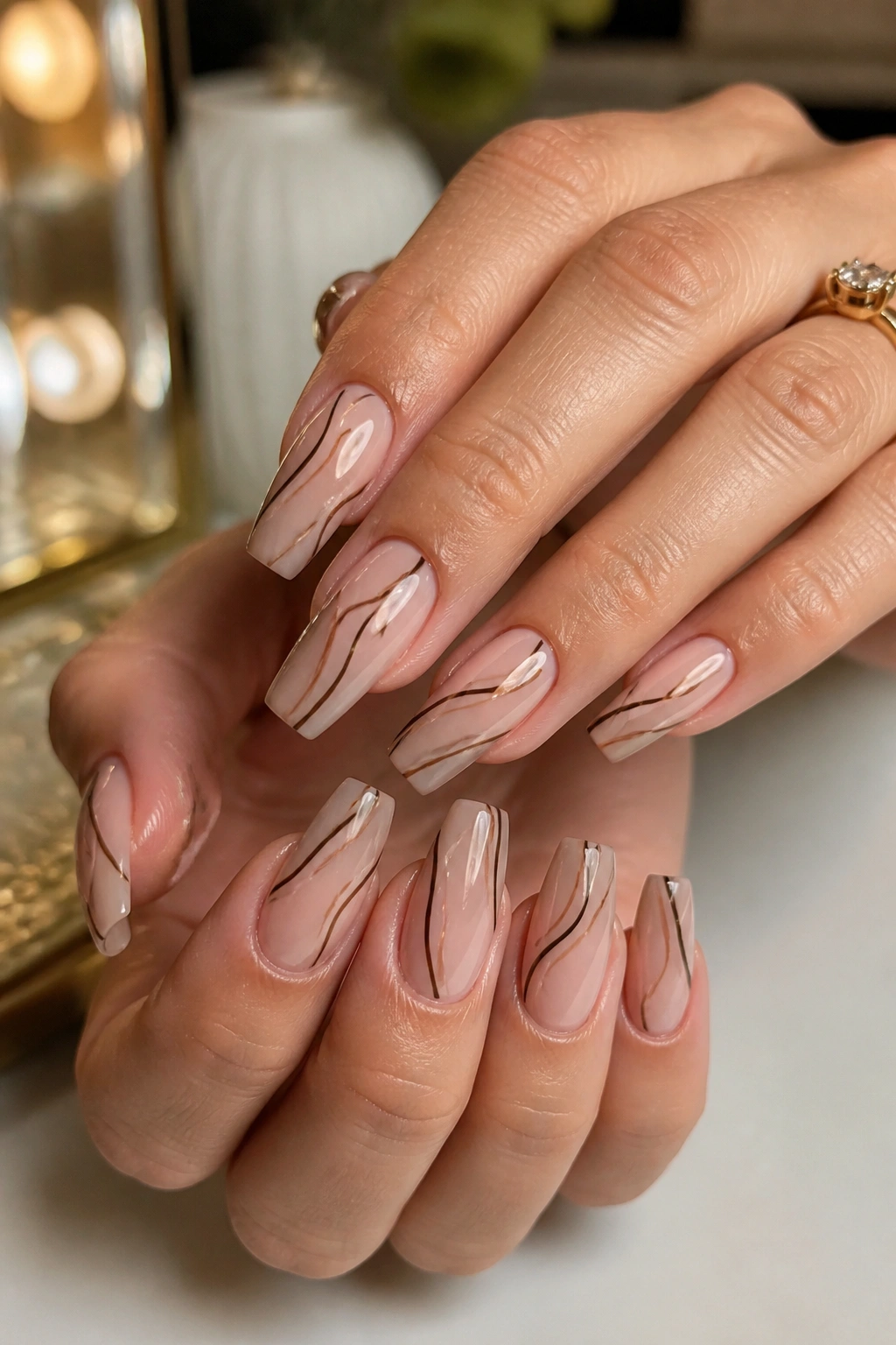 Close-up of real hands with chocolate brown micro-swirls on coffin nails
