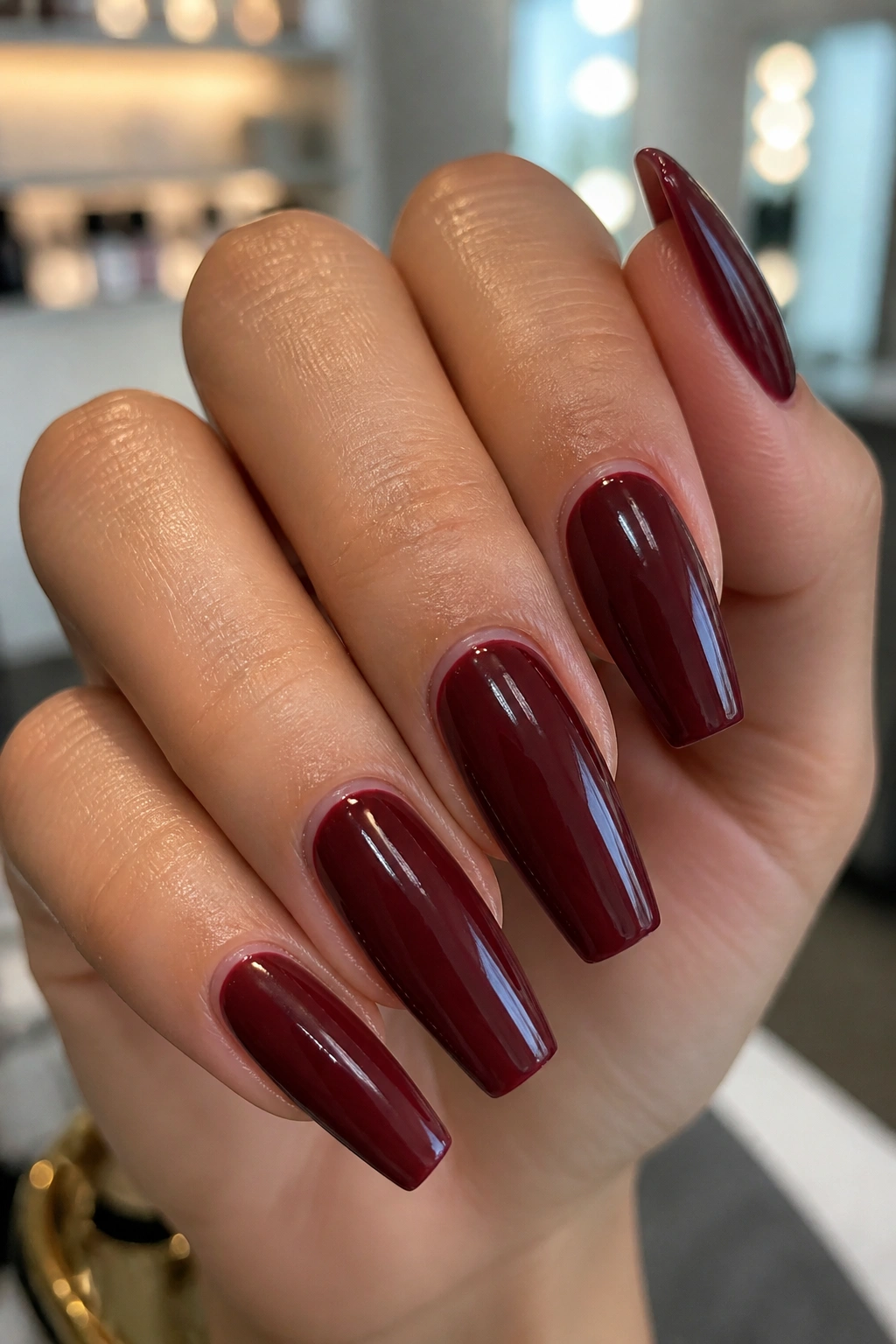 Close-up of burgundy coffin nails showing crisp cuticle line and smooth edges.
