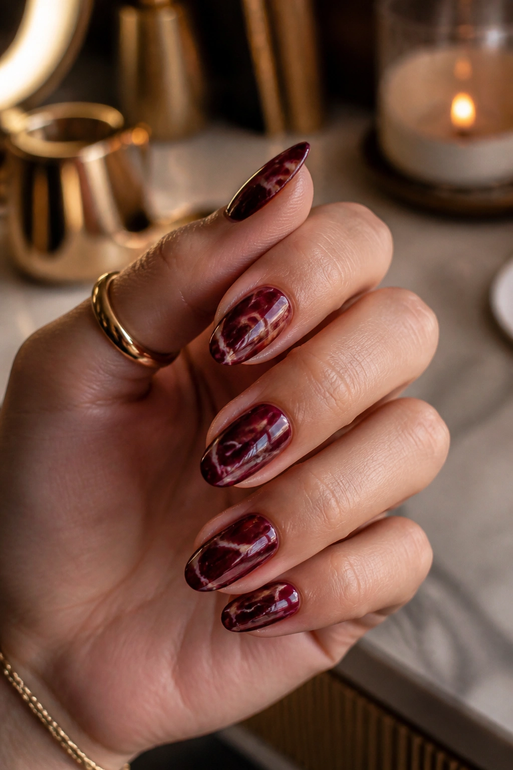 Shorter almond nails in burgundy marble with light veins
