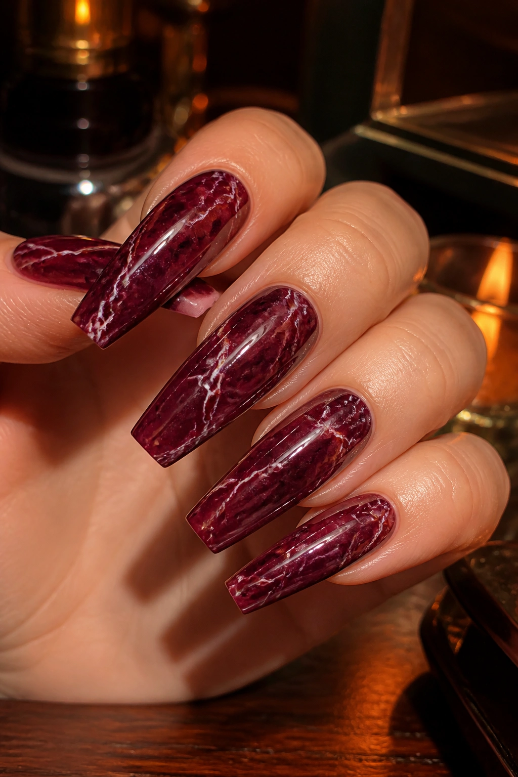 Close-up of deep burgundy marble coffin nails with high-gloss finish