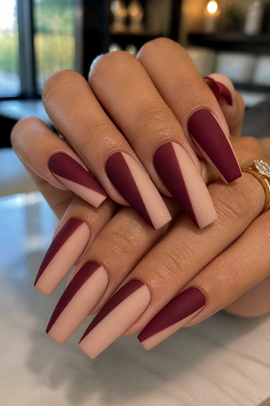 Close-up of coffin nails with burgundy and nude color-block design
