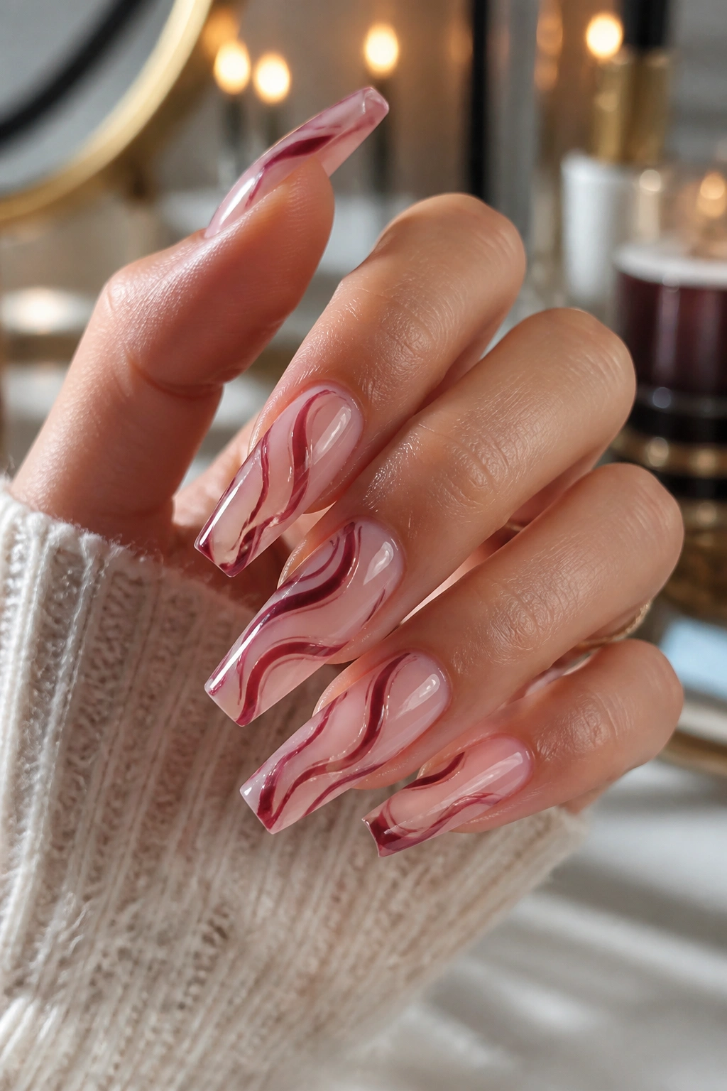 Close-up of burgundy swirl coffin nails on a sheer base