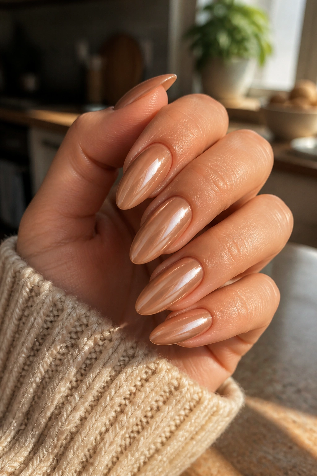 Almond nails in caramel nude chrome with warm sunlight.