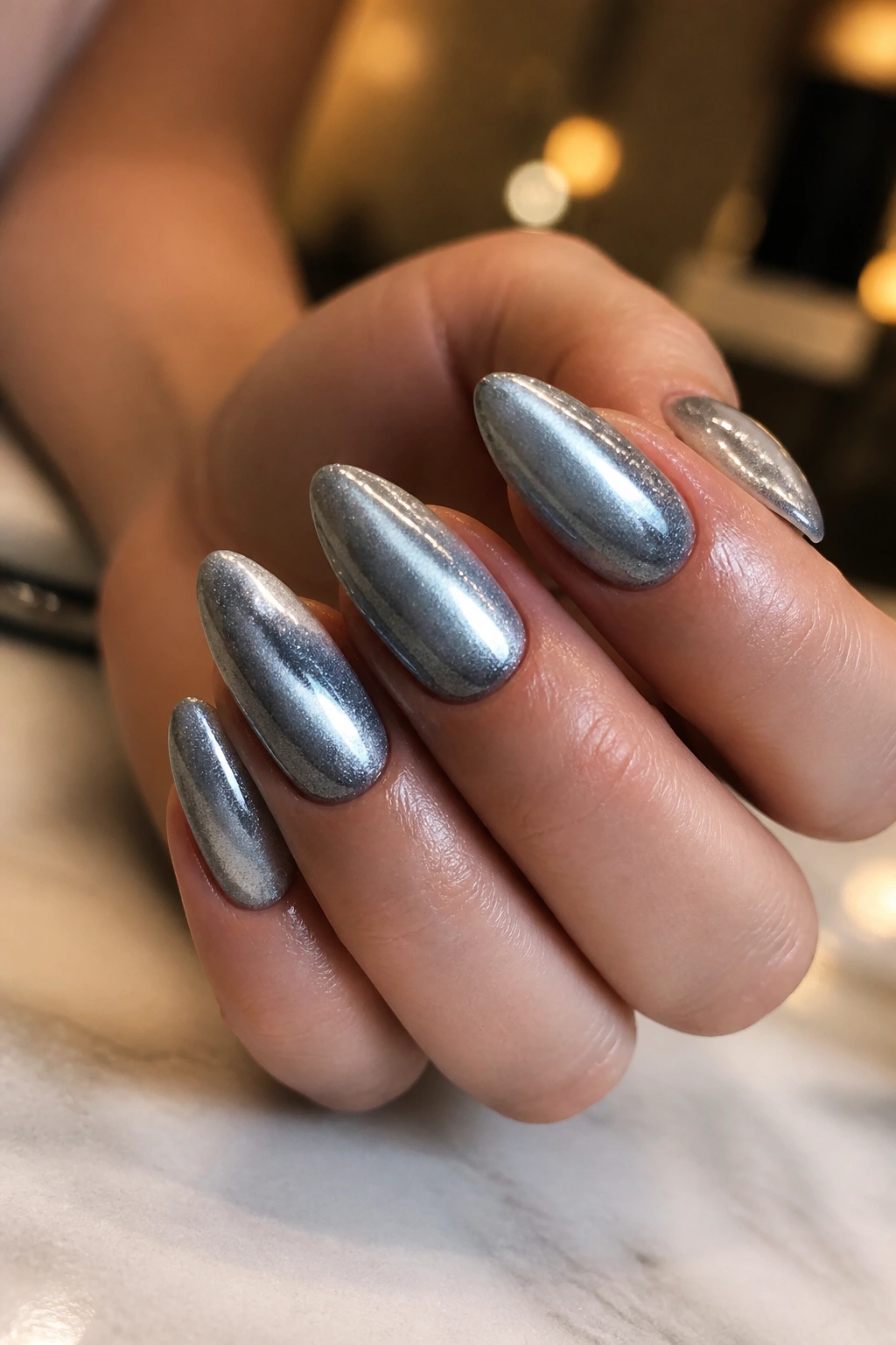 Close-up of cat-eye silver almond nails on a real hand