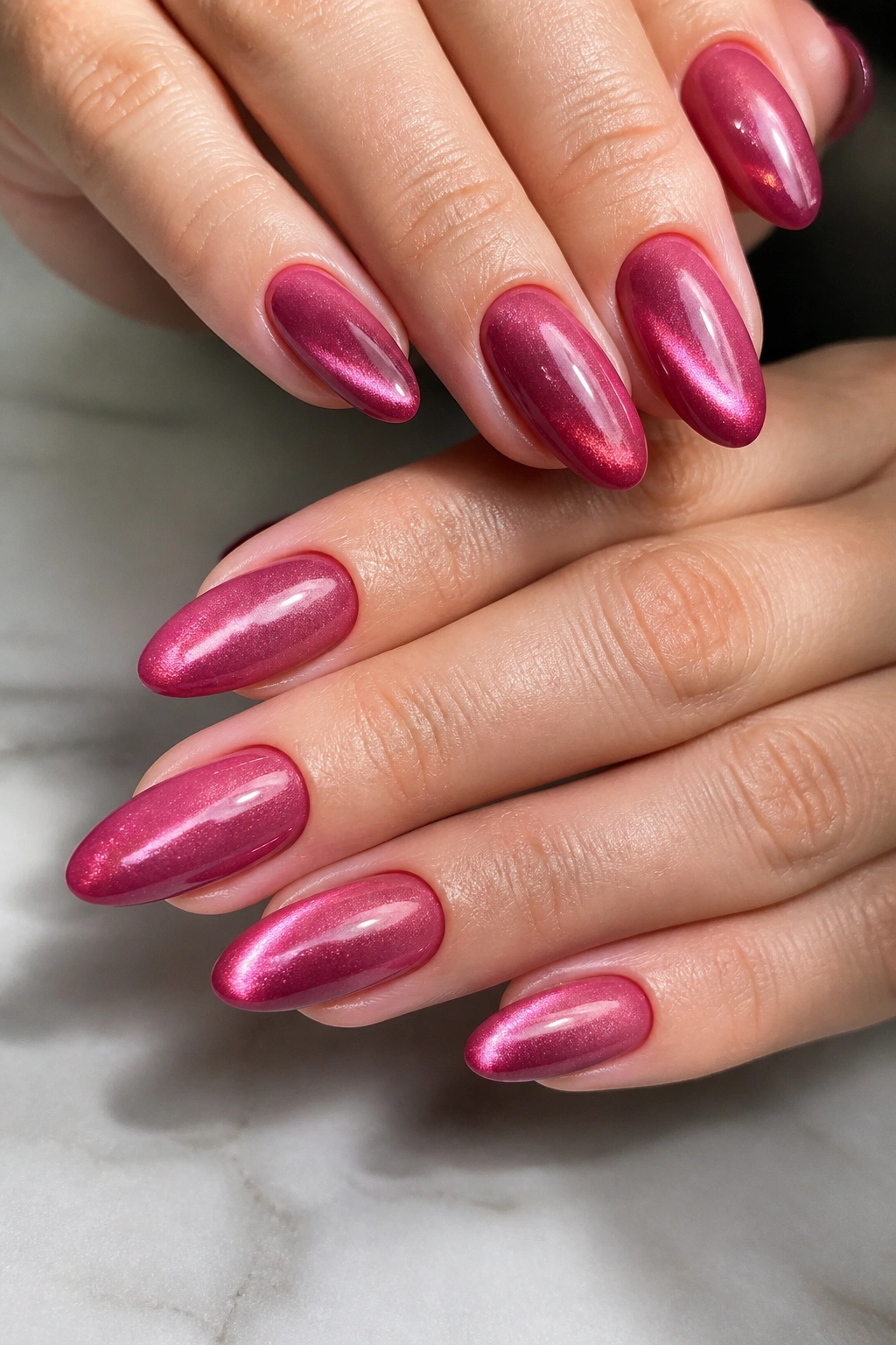 Velvet cat-eye pink almond nails close-up with subtle stripe