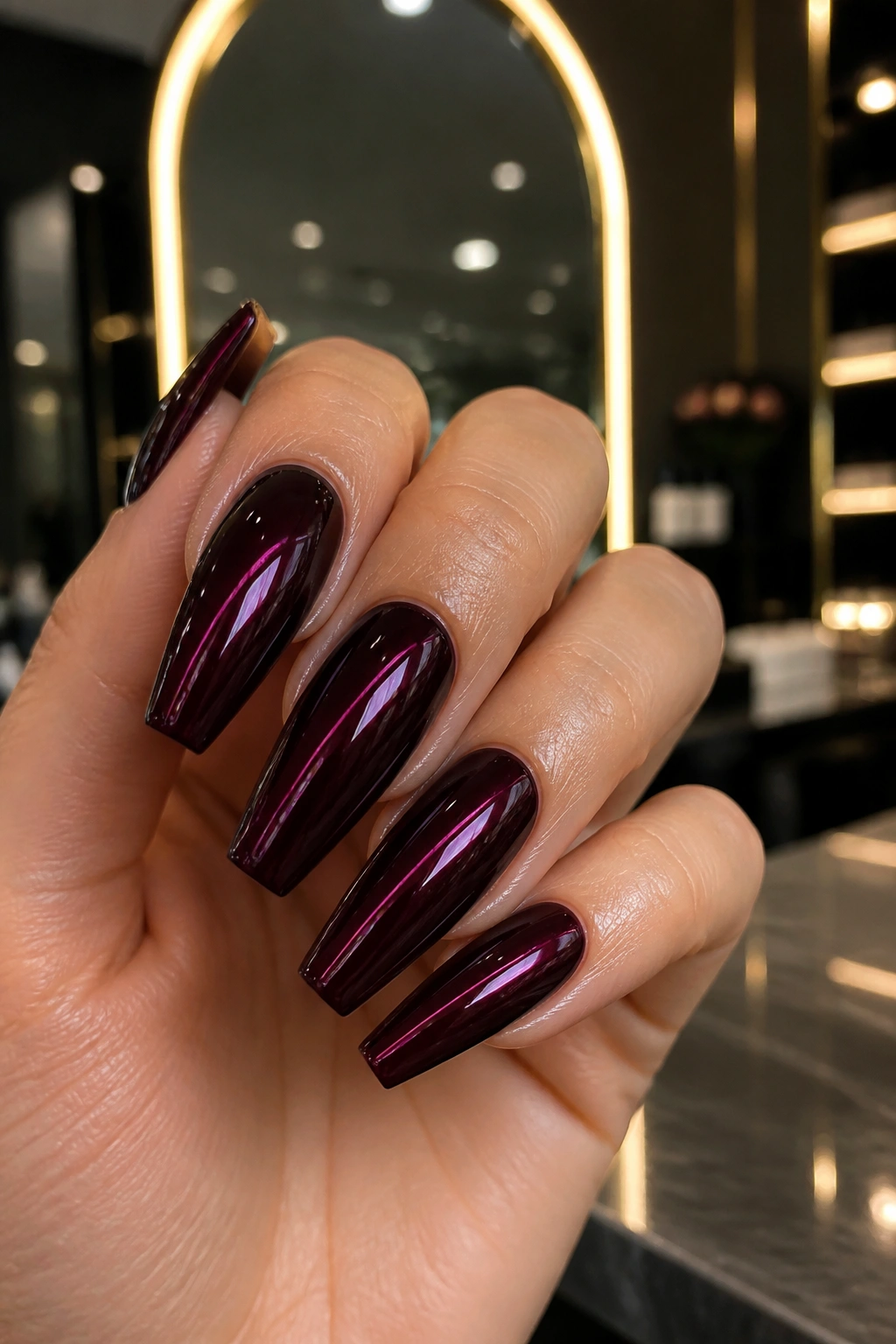 Close-up of black cherry chrome burgundy coffin nails on a real hand
