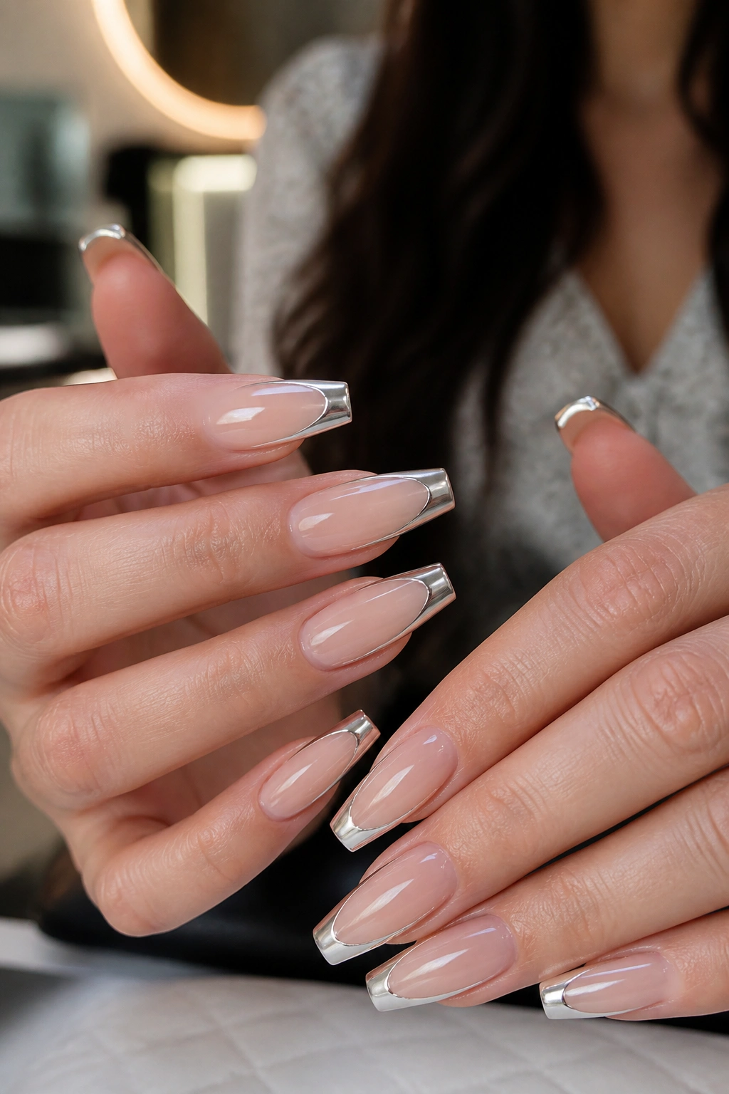 Close-up of hands with Chrome French Tip Coffin Nails showing silver chrome tips