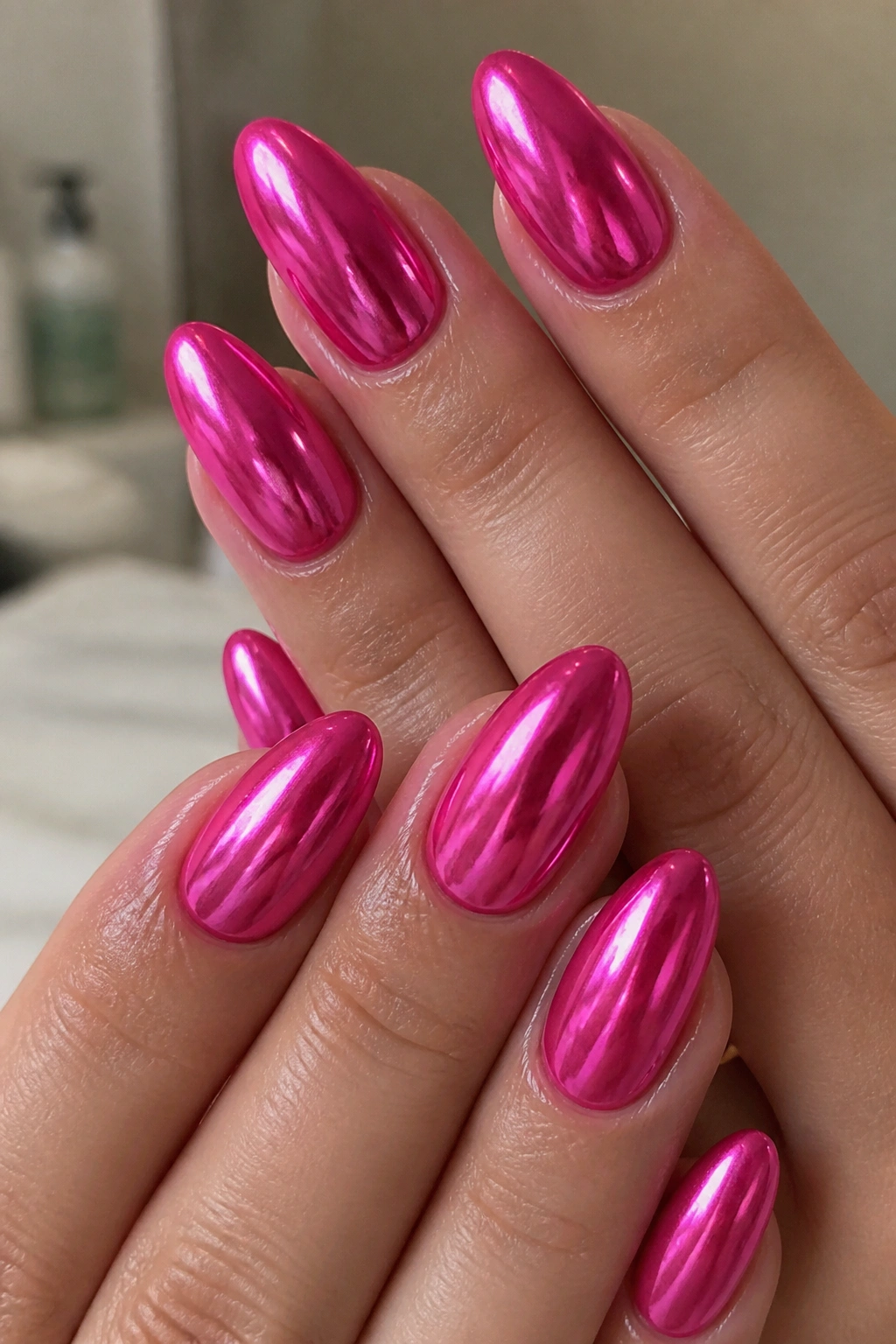 Almond nails with hot pink chrome finish close-up on real hand