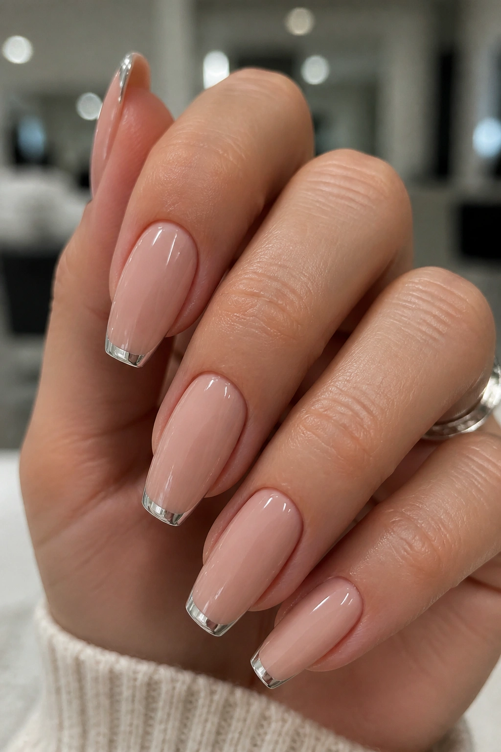 Close-up of nails with silver chrome French tips on a nude base