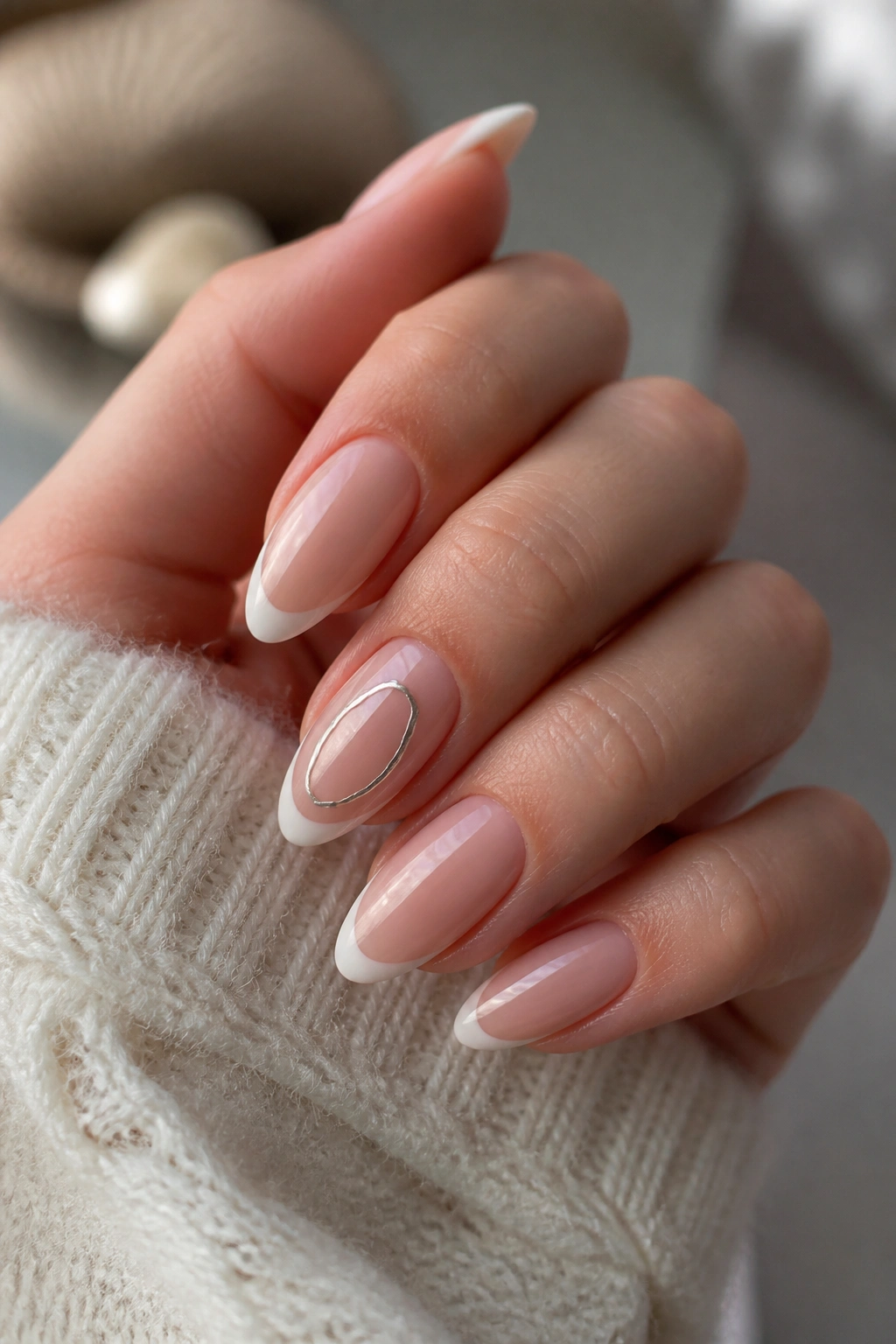 Almond nails with a chrome-outline glyph on a French tip manicure