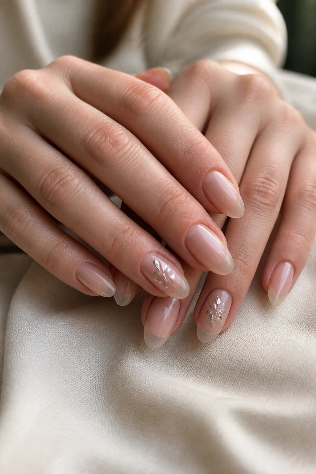 Close-up of almond nails with clear base and a tiny accent nail detail