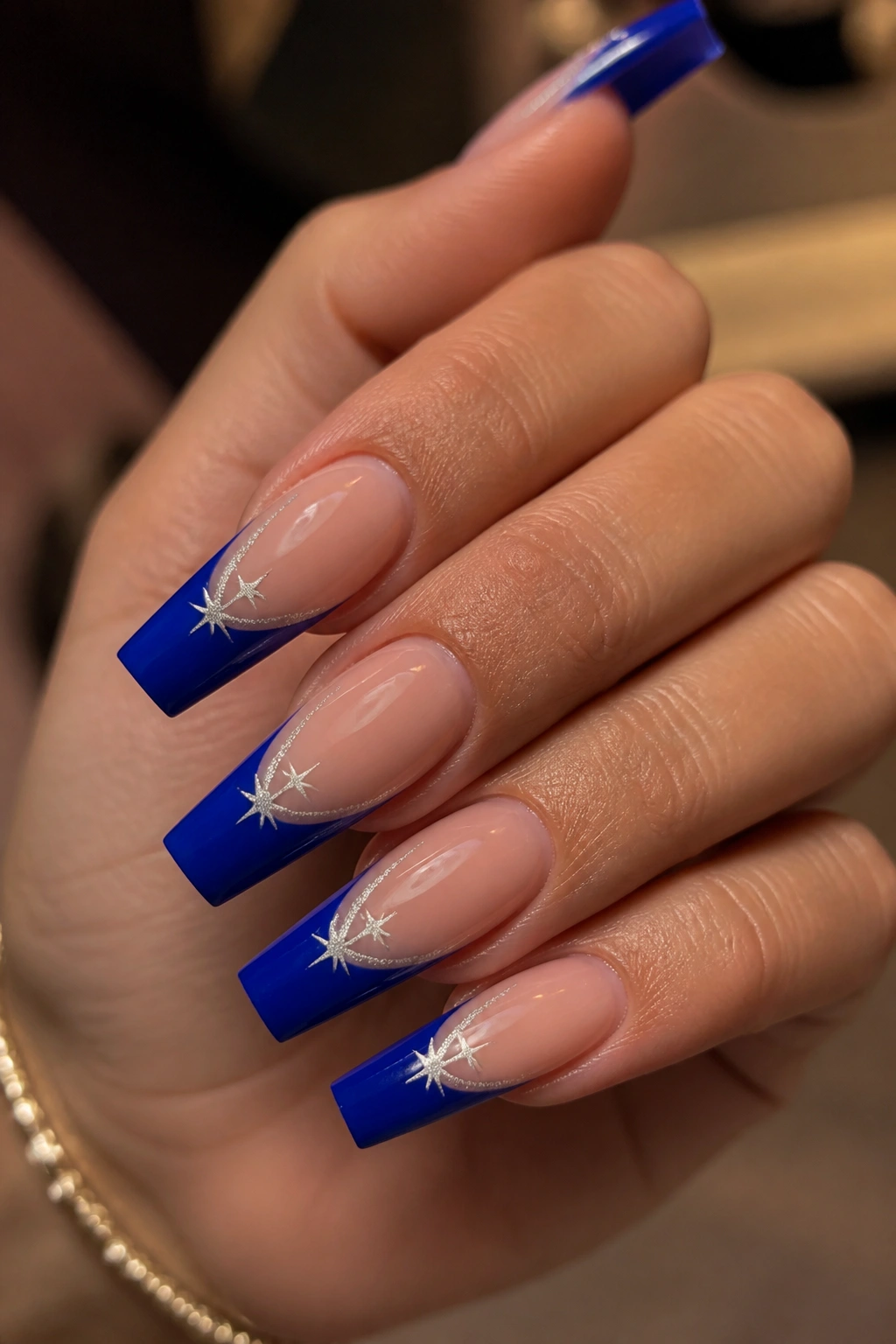 Cobalt blue tip nails with shooting star trail design on real hand