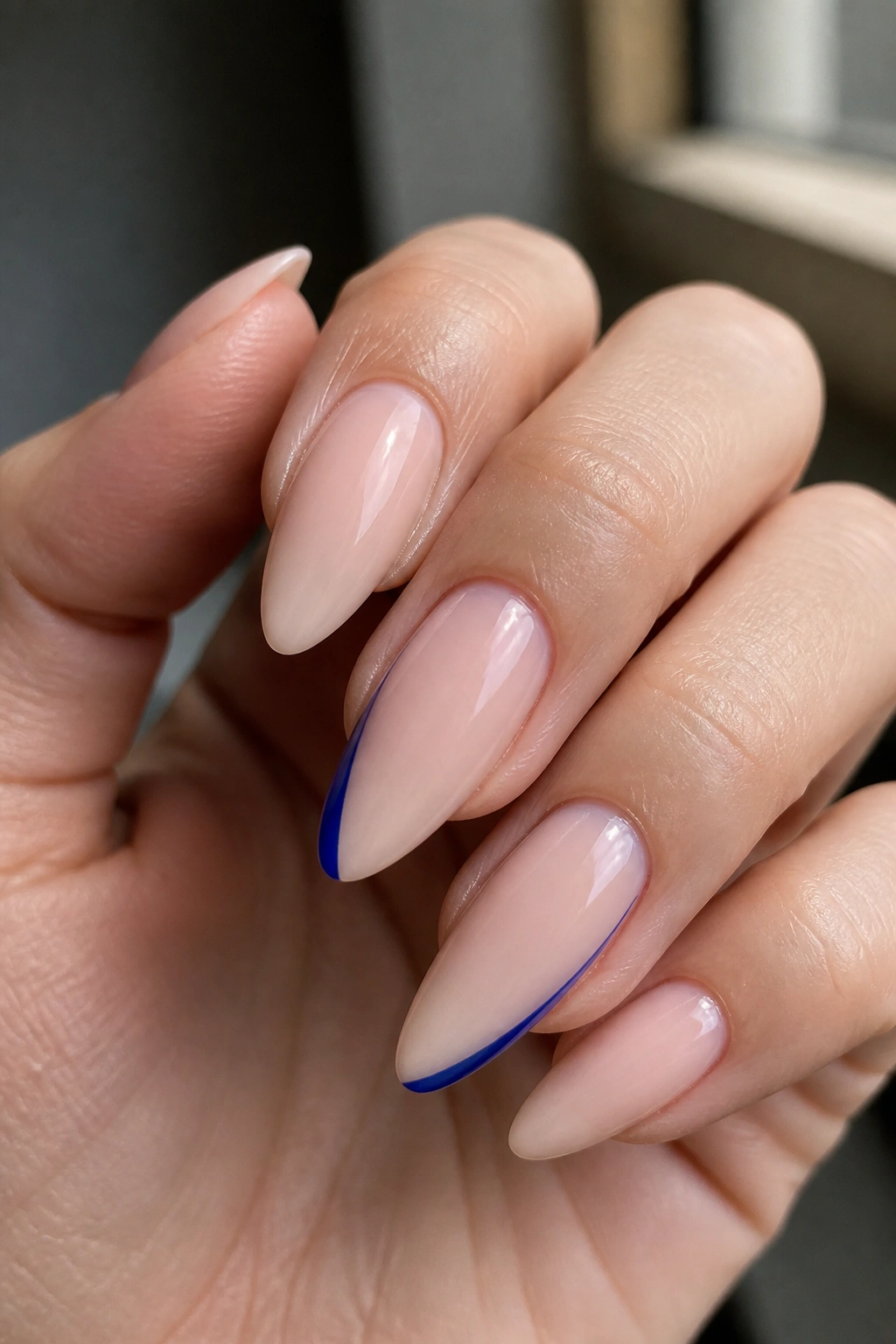Almond nails with cobalt diagonal side sweep close-up.