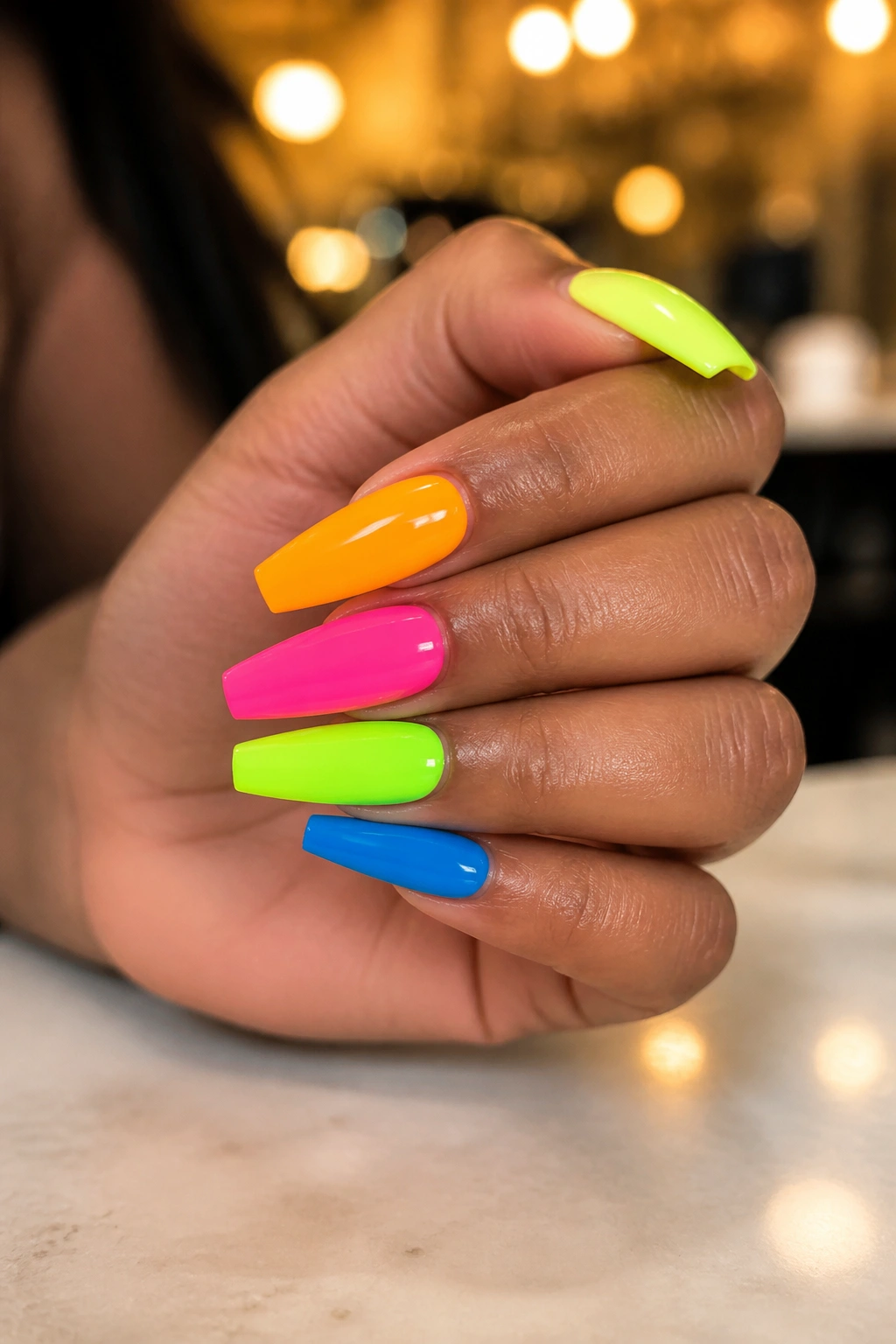 Close-up of a real hand with bright coffin nails on medium-length nails in a neon manicure