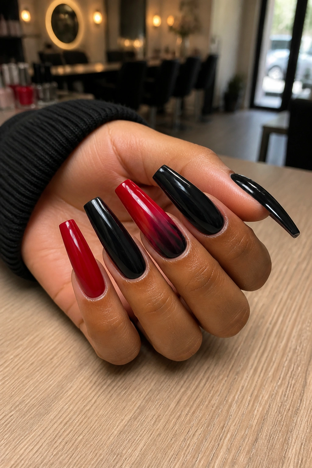 Close-up of red and black coffin nails on a real hand in a stylish salon