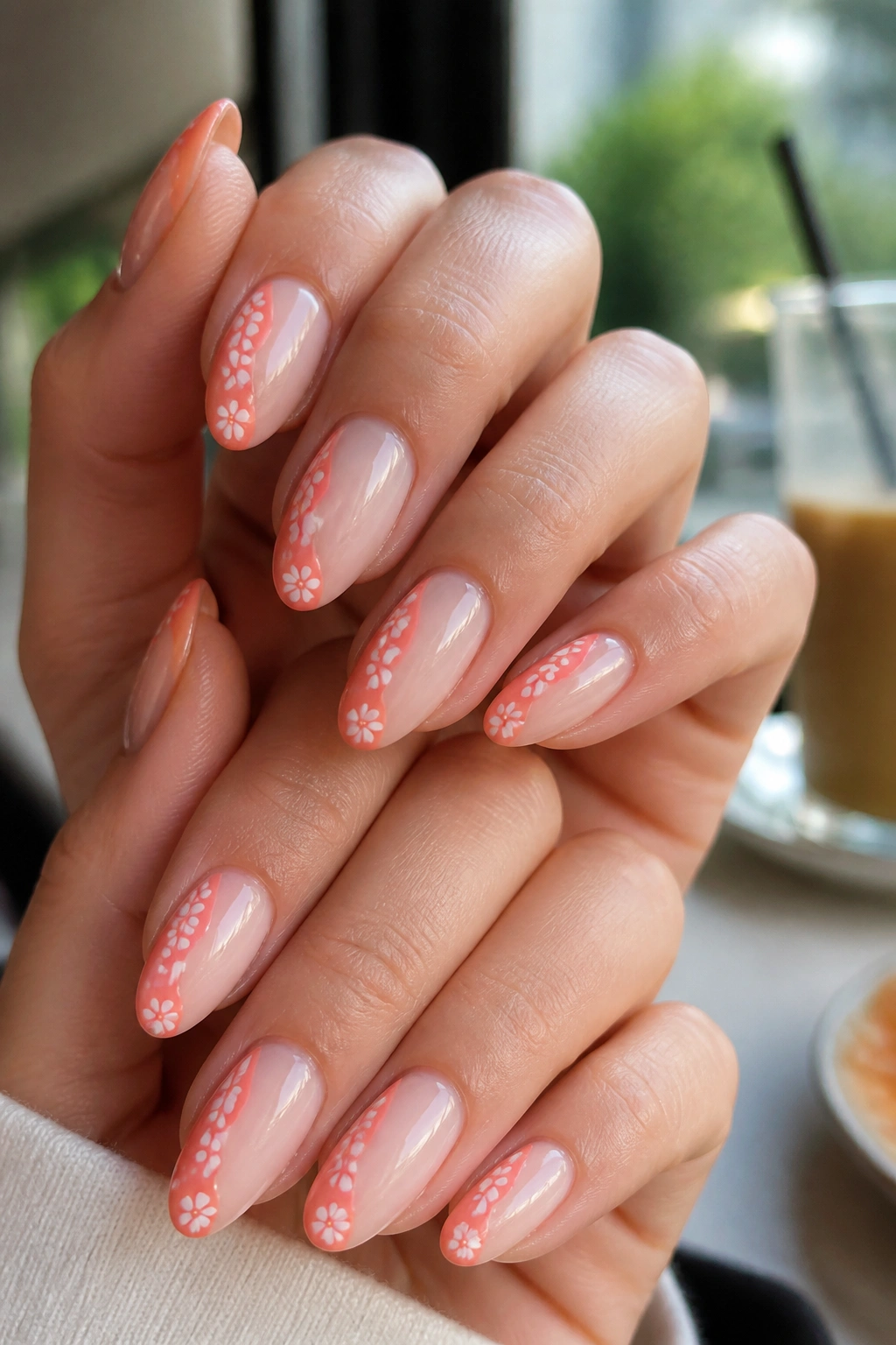 Almond nails with coral ribbon florals and negative space on a real hand