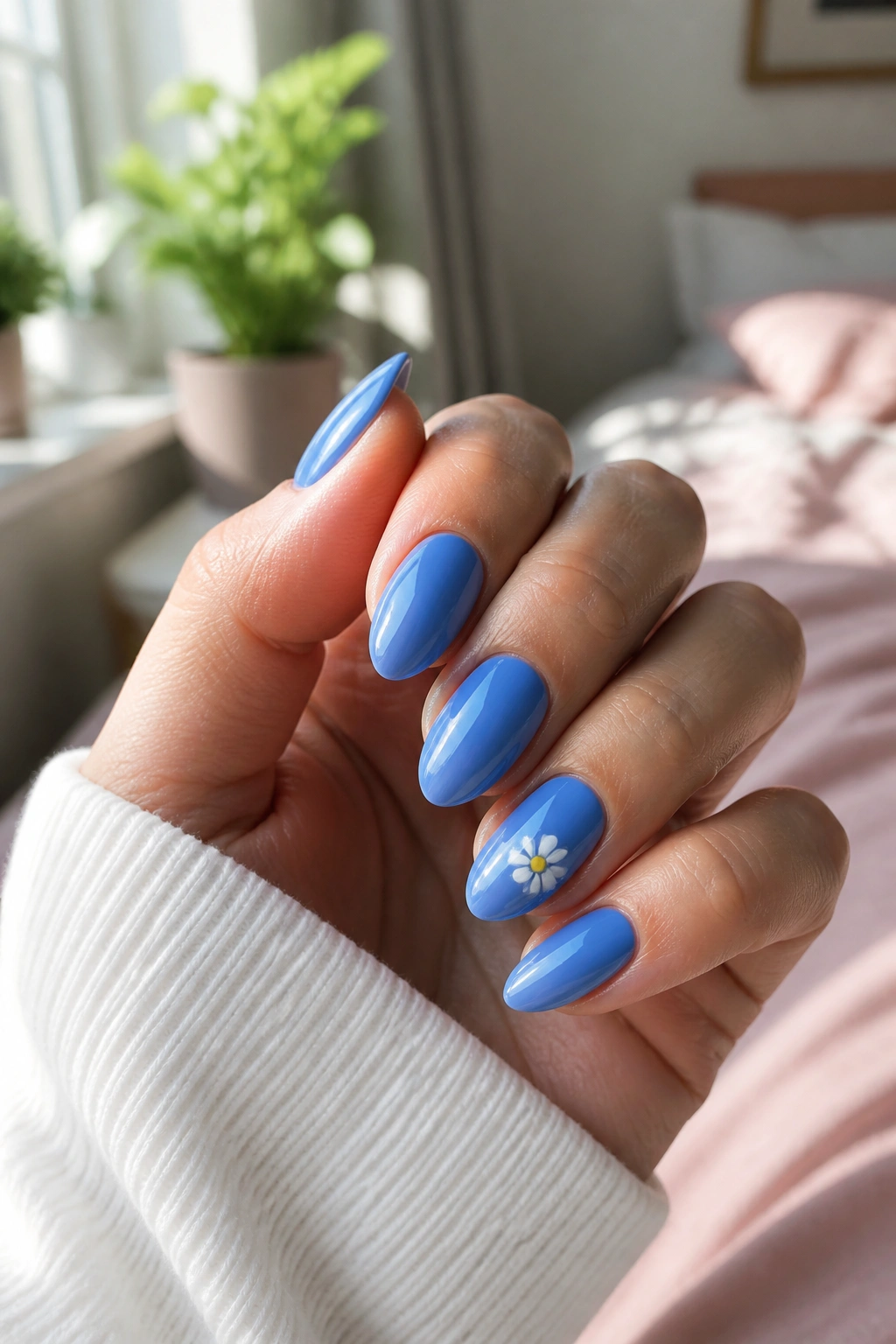 Almond nails with cornflower blue base and white daisy accent on one nail