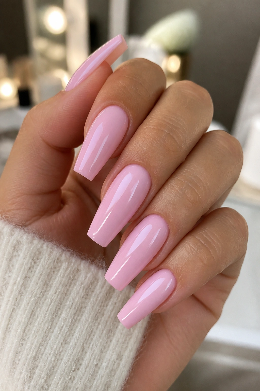 Creamy pink coffin nails with high gloss on a real hand