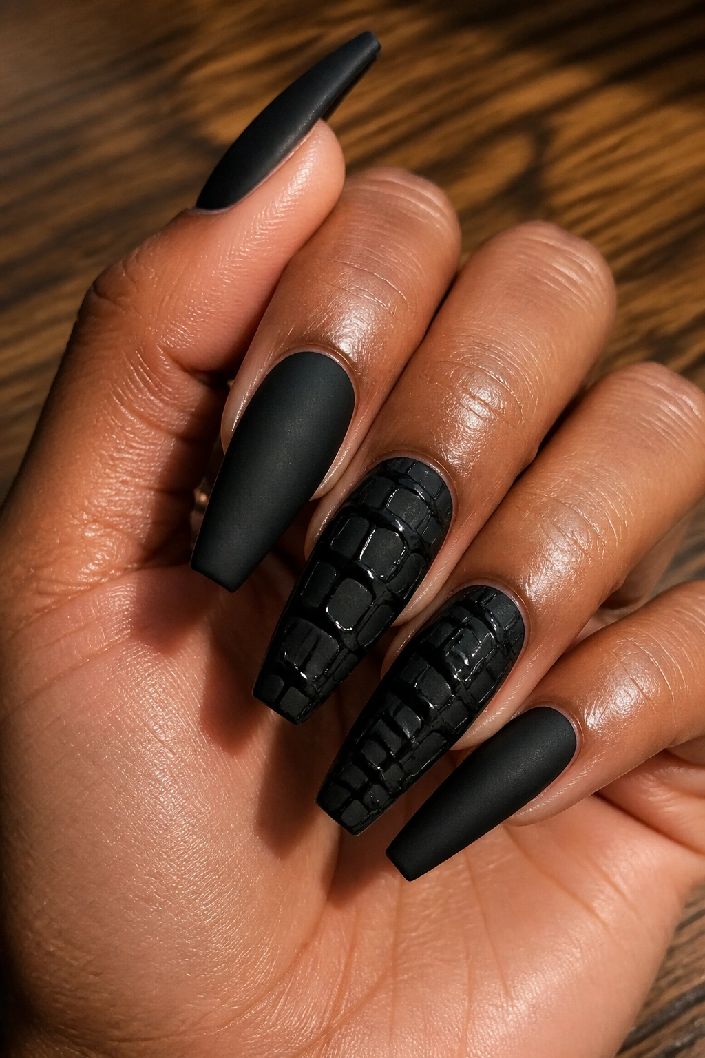Close-up of croc-textured black coffin nails on real hand